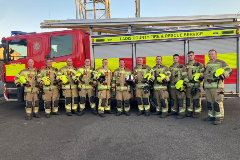 Image shows Mountrath Fire Fighters standing next to their Fire Truck