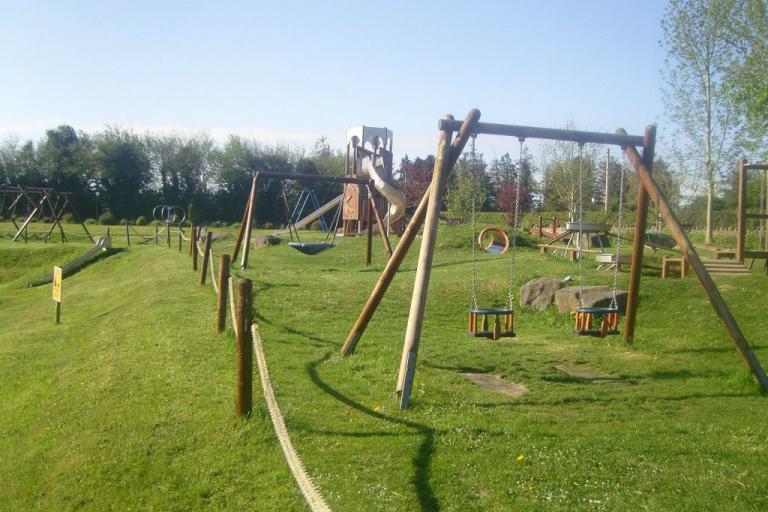 the swings in clonaslee playground on a sunny day 