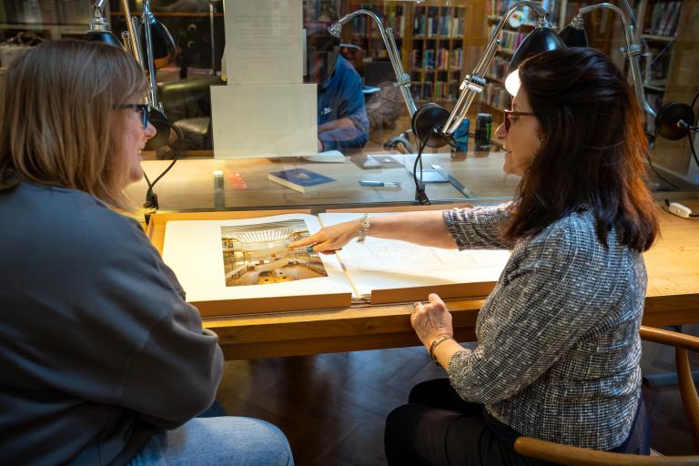 2 women viewing a book in library