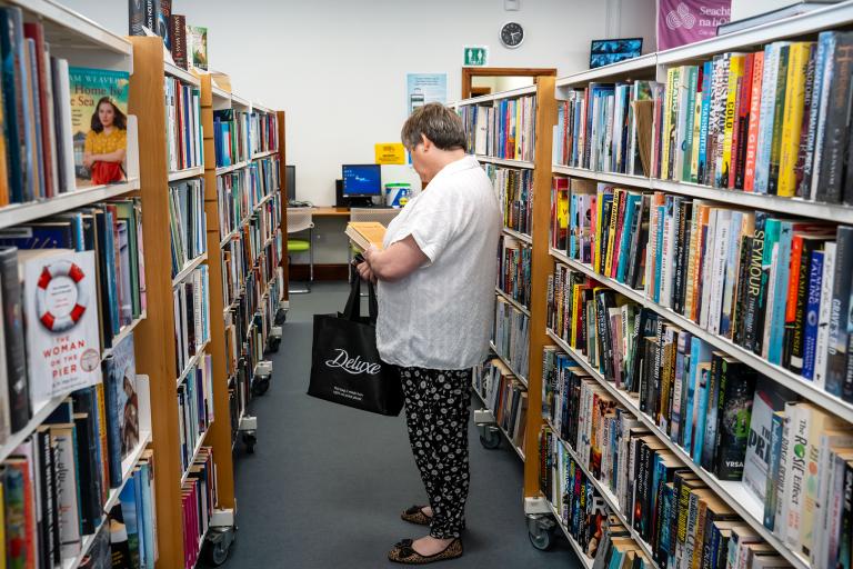 Woman browsing shelves in library