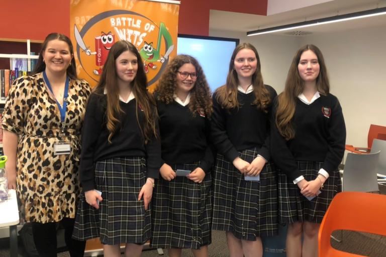 Teenage girls in library with librarian