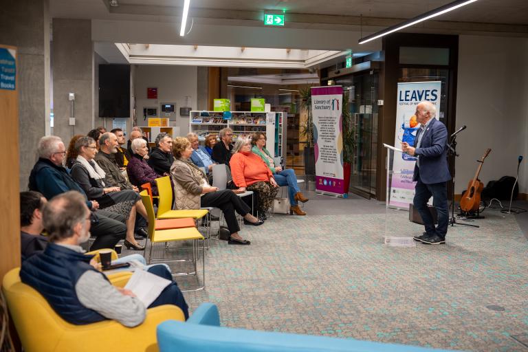 Audience listening to author at book launch in library