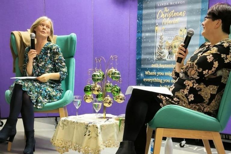 2 women in conversation about book in library