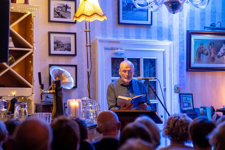 Author reading from book in front of audience