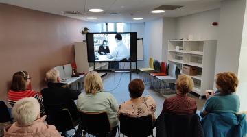 People viewing a film in the library