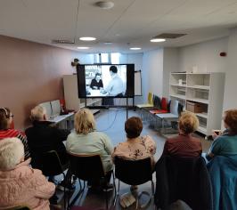 People viewing a film in the library