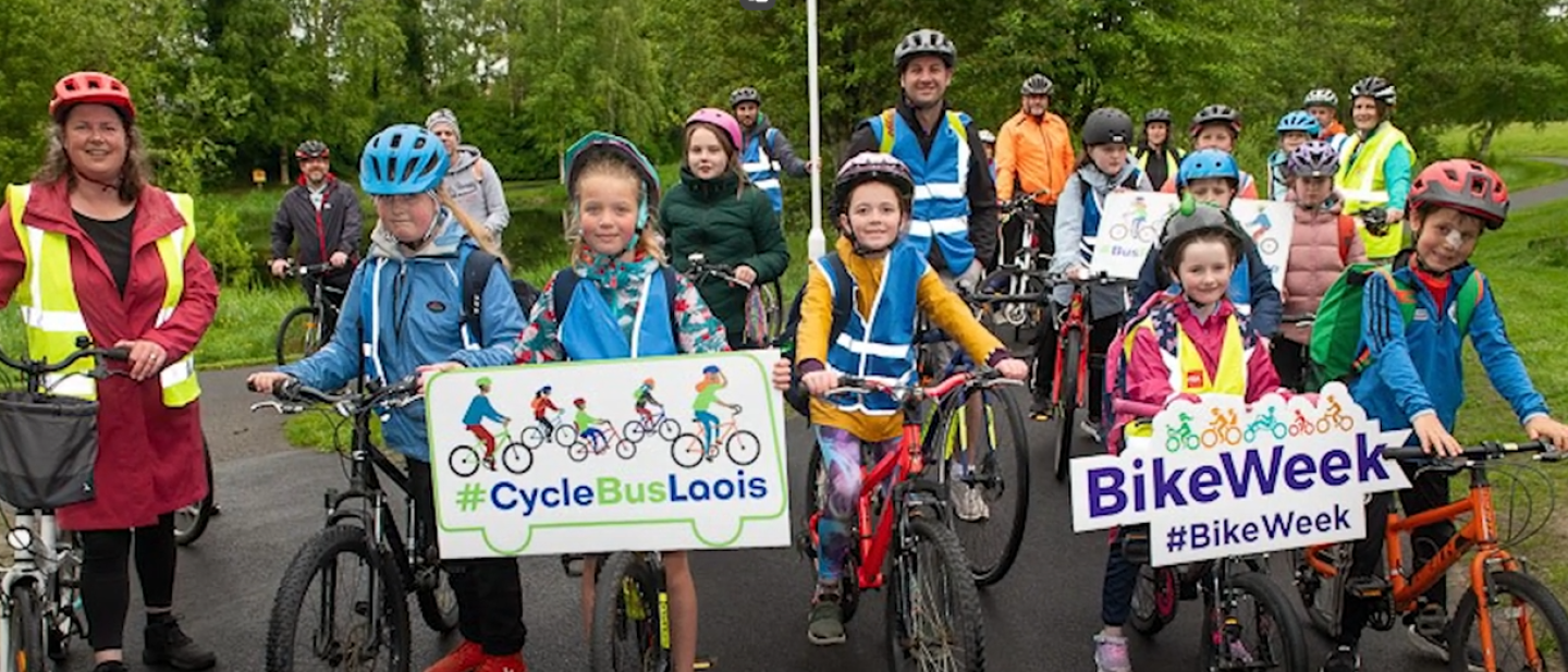 School children on their bikes holding up signs for Bike Week